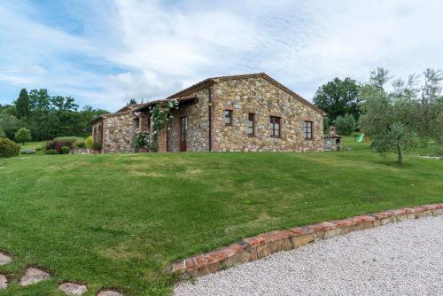 an old stone house on a grassy yard at Aurora Agriturismo in San Casciano dei Bagni