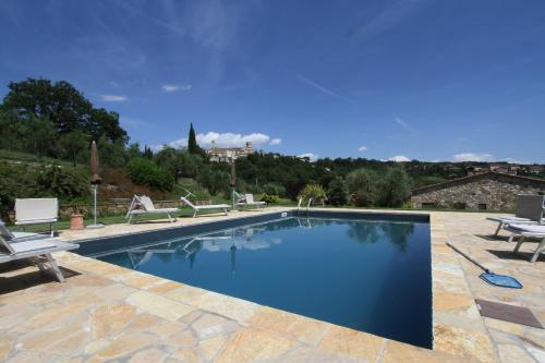 a swimming pool with two chairs and a table at Aurora Agriturismo in San Casciano dei Bagni
