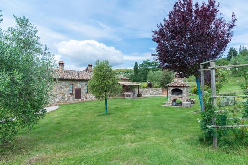 a stone house with a yard with a gazebo at Aurora Agriturismo in San Casciano dei Bagni