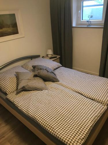a bed with pillows on it in a bedroom at Haus Marianne in Ettersburg