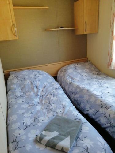 Habitación pequeña con 2 camas en una habitación en Caravan ( Static, within a super holiday park ) en Birchington