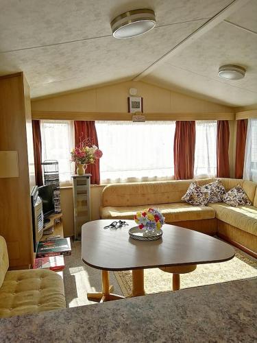 uma sala de estar com um sofá e uma mesa em Caravan ( Static, within a super holiday park ) em Birchington