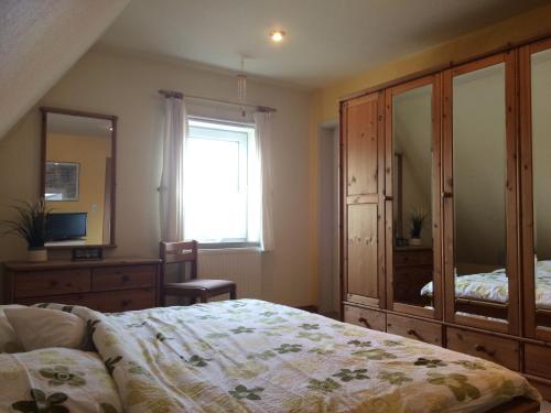 a bedroom with a bed and a dresser and a mirror at Hus Nordhauk in Borkum