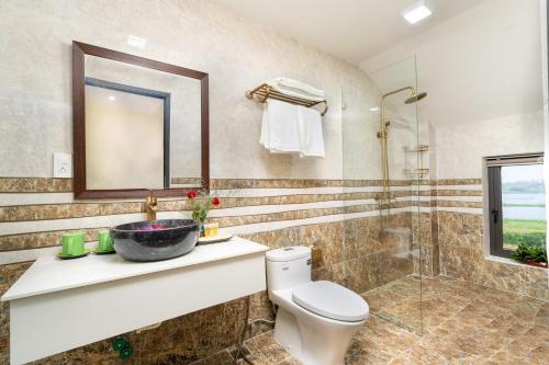 a bathroom with a toilet and a sink and a shower at Ancient River Villa in Hoi An