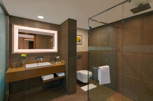 a bathroom with a toilet and a sink and a shower at Novotel Ahmedabad in Ahmedabad
