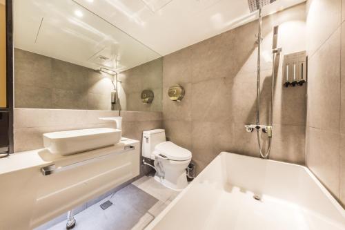 a bathroom with a tub and a toilet and a sink at Forestar Hotel Sinchon in Seoul