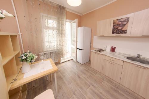 a kitchen with a sink and a refrigerator at Заречная 1-ая, 6 in Kemerovo