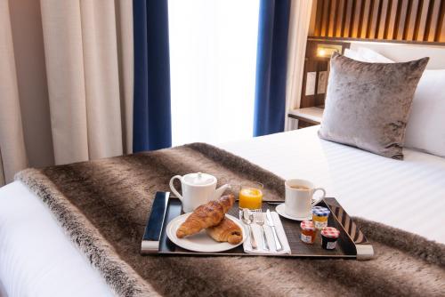 a tray with breakfast foods on a bed at Lord Byron in Paris
