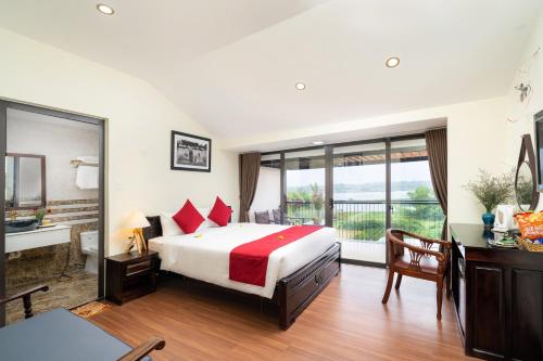 a bedroom with a bed and a desk and a window at Ancient River Villa in Hoi An