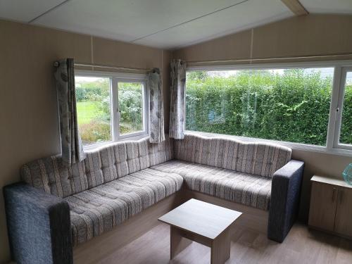 a living room with a couch and two windows at de Schelphoeve in Ellemeet