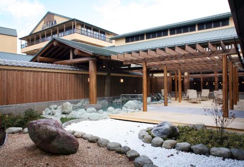 a building with a pavilion with rocks in a yard at Highland Resort Hotel & Spa in Fujiyoshida