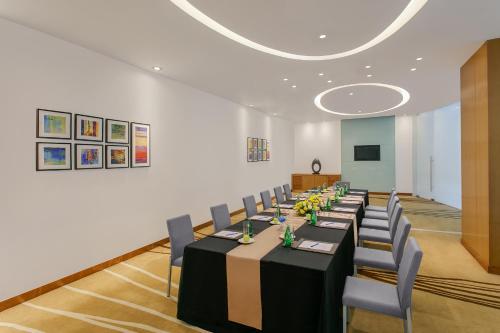 a conference room with a long table and chairs at Novotel Ahmedabad in Ahmedabad