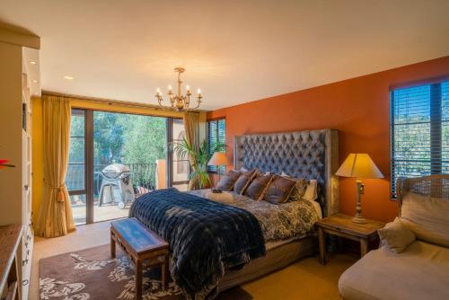 een slaapkamer met een bed en een groot raam bij San Marco Luxury Beachside Villa in Whangamata