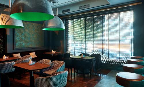 a restaurant with tables and chairs and a large window at Il Decameron Luxury Design Hotel in Odesa