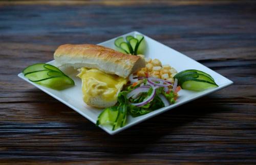 a plate with a sandwich and salad on a table at Chau Long Sapa 2 Hotel in Sa Pa