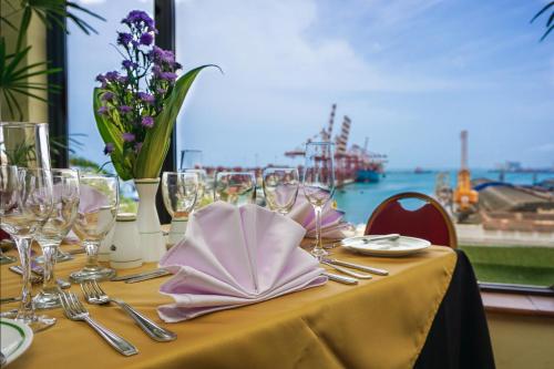 a table with glasses and napkins on it with a view of the ocean at Grand Oriental Hotel in Colombo