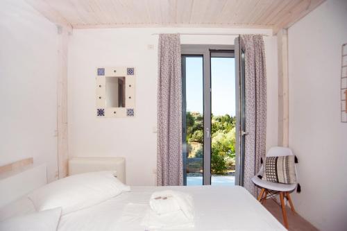 um quarto branco com uma cama e uma janela em LAURA_SEA VIEW_HOUSE em Katouna
