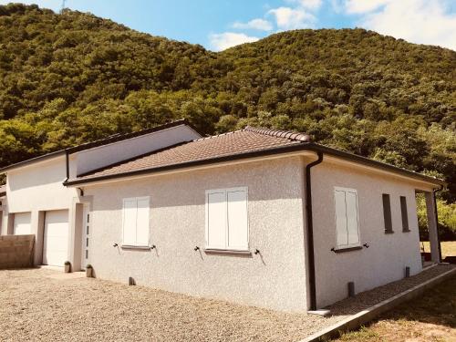 a white building with a mountain in the background at VILLA VACANCES NEUVE in Bompas