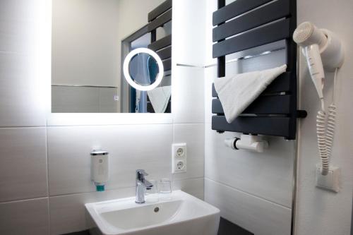 a bathroom with a sink and a mirror at Hotel im Kaiserpark in Meiningen