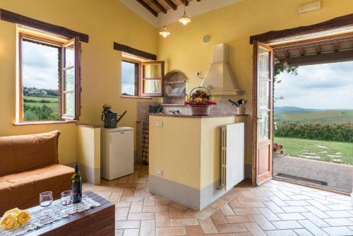a kitchen with a refrigerator and a table in a room at Aurora Agriturismo in San Casciano dei Bagni