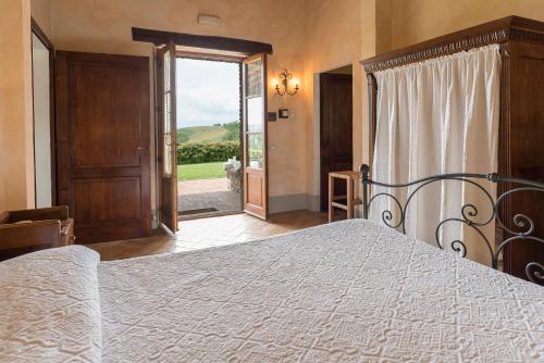 a bedroom with a bed and a sliding glass door at Aurora Agriturismo in San Casciano dei Bagni