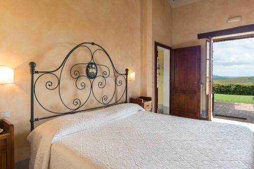 a bedroom with a bed and a large window at Aurora Agriturismo in San Casciano dei Bagni