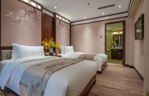 a hotel room with three beds and a hallway at Doof Resort Hotel in Lijiang