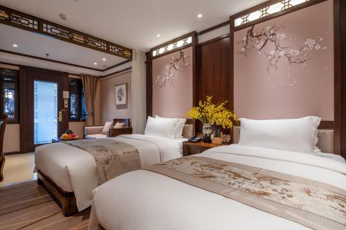 a hotel room with three beds in a room at Doof Resort Hotel in Lijiang