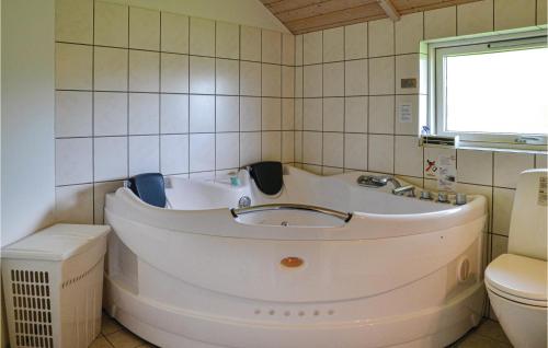 La salle de bains est pourvue d'une baignoire blanche et de toilettes. dans l'établissement Nice Home In Hovborg With Kitchen, à Hovborg