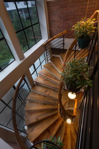 a wooden spiral staircase with two potted plants at Sha Ri Loum Homestay in Shillong