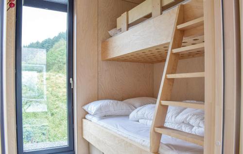 a bunk bed in a tiny house with a window at Nice Home In Lyngdal With 3 Bedrooms And Wifi in Lyngdal
