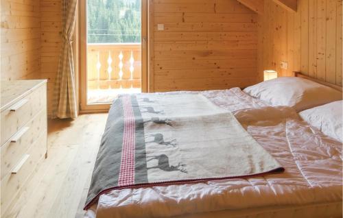 a bed with a blanket on it in a room with a window at Gemuetliches Almhaus in Flattnitz