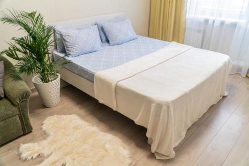 a bedroom with a bed with a blue blanket and a rug at Апартаменты Красная, 10Б in Kemerovo