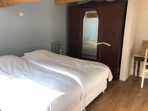 a bedroom with a white bed and a mirror at Halte Bontebrug in Silvolde