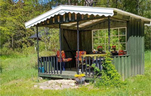 un petit hangar avec une table et des chaises dans un champ dans l'établissement Cozy Home In Munka-Ljungby With Kitchen, à Munka-Ljungby