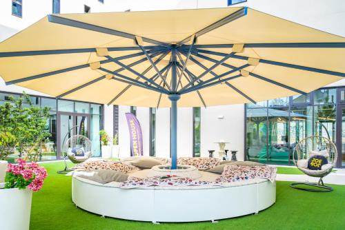 a large yellow umbrella sitting on top of a table at JO&JOE Paris Gentilly - Auberge de Jeunesse in Gentilly