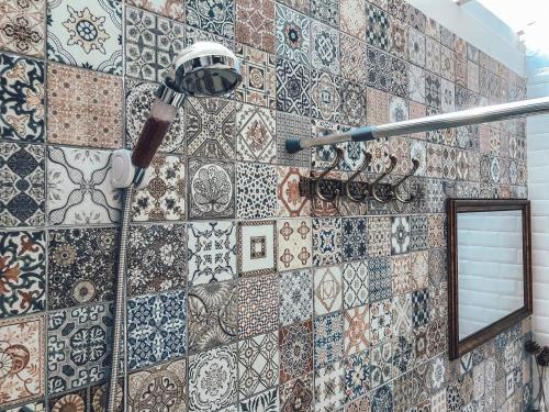 a bathroom with a tiled wall with a shower at Baan Suan Krung Kao in Phra Nakhon Si Ayutthaya