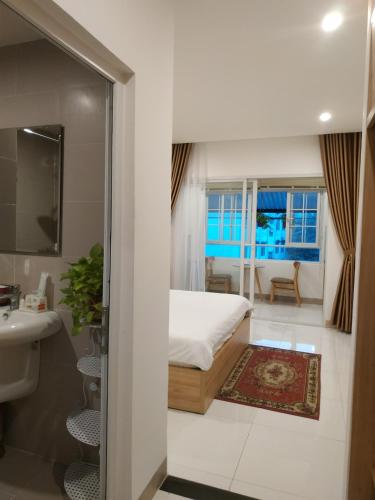 a bedroom with a bed and a bathroom with a sink at Minh Apartment in Danang