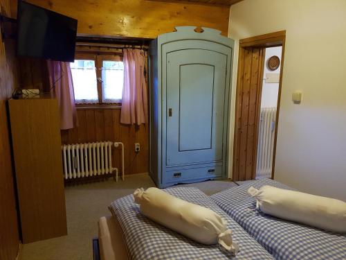 um quarto com duas camas e uma televisão e uma porta em Ferienwohnung Kraihof, 83703 Gmund am Tegernsee em Gmund am Tegernsee
