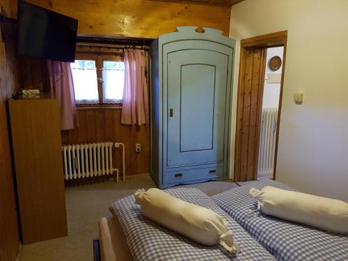 a bedroom with two beds and a tv and a door at Ferienwohnung Kraihof, 83703 Gmund am Tegernsee in Gmund am Tegernsee