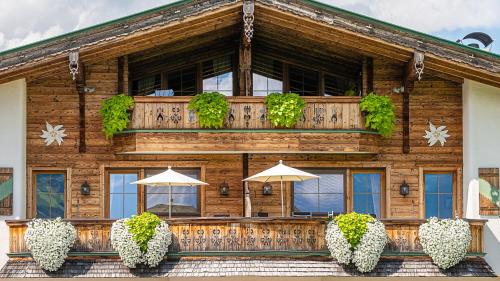 a wooden building with umbrellas in front of it at Aparthotel Stacherhof in Fügen