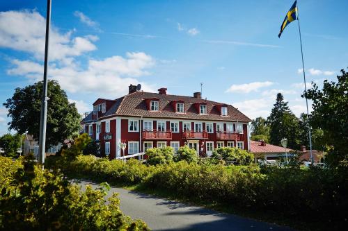 une grande maison rouge avec un drapeau devant elle dans l'établissement Smålandsgården, à Gränna