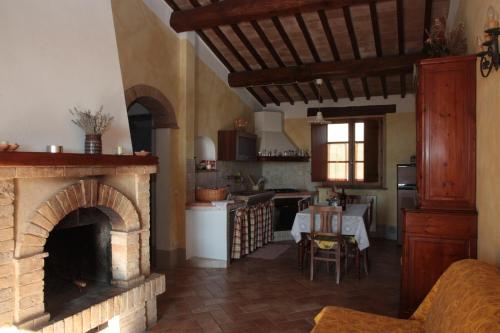 a kitchen with a brick fireplace and a dining room at Aurora Agriturismo in San Casciano dei Bagni