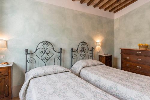 a bedroom with two beds and a dresser at Aurora Agriturismo in San Casciano dei Bagni