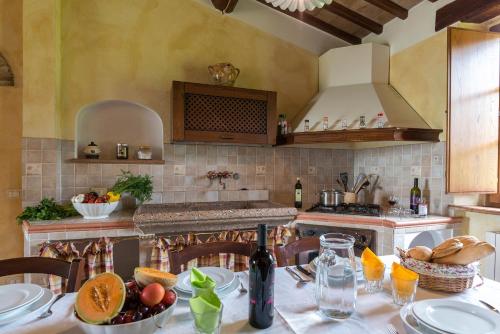a kitchen with a table with a bowl of fruit at Aurora Agriturismo in San Casciano dei Bagni