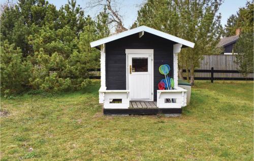 a black and white dog house in a yard at Gorgeous Home In Skivarp With Sauna in Skivarp