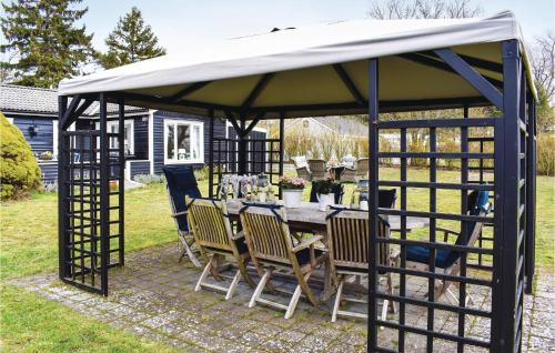 a gazebo with a table and chairs under it at Gorgeous Home In Skivarp With Sauna in Skivarp
