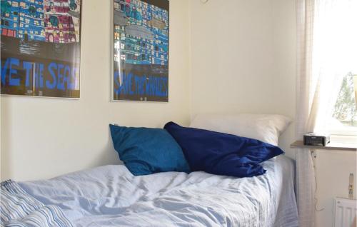 a bed with two blue pillows in a bedroom at Gorgeous Home In Skivarp With Sauna in Skivarp