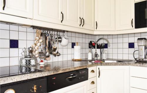 a kitchen with white cabinets and a black dishwasher at Gorgeous Home In Skivarp With Sauna in Skivarp