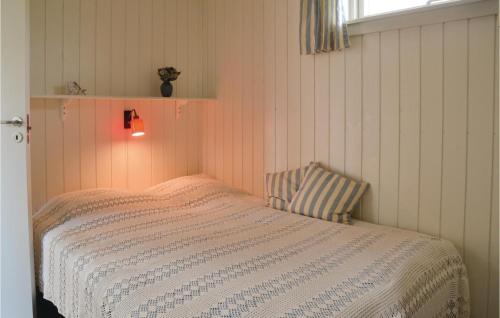a bedroom with a bed and a light on the wall at Pet Friendly Home In Esbjerg V With House Sea View in Esbjerg